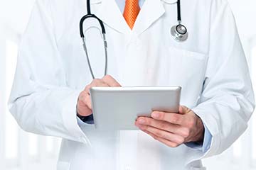 врач в белом халате с планшетом в руках
